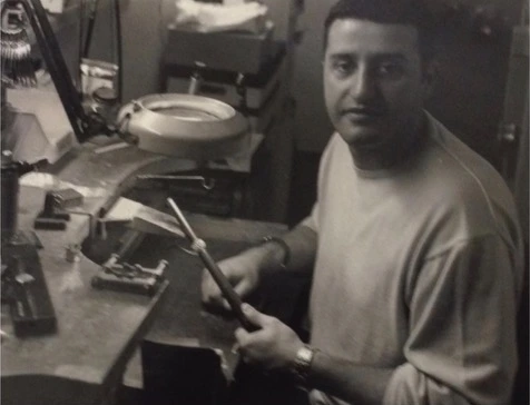An archival photograph of a jeweller at a workbench